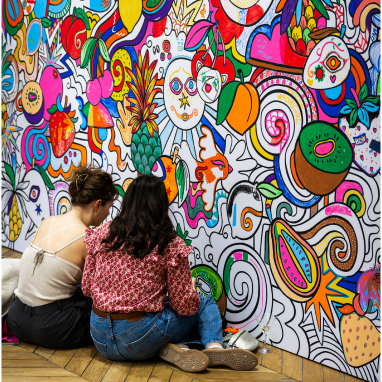 People coloring vibrant fruit and abstract mural